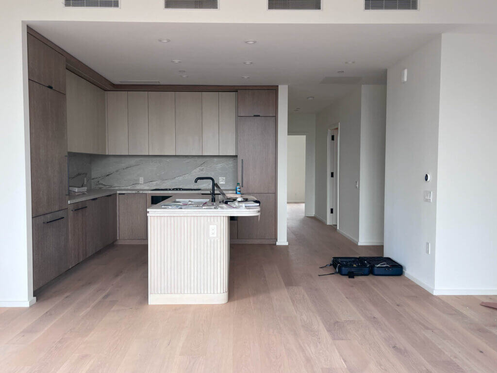 Kitchen with oak cabinets, flooring, stone backsplash, luxury interior design in NYC apartment.