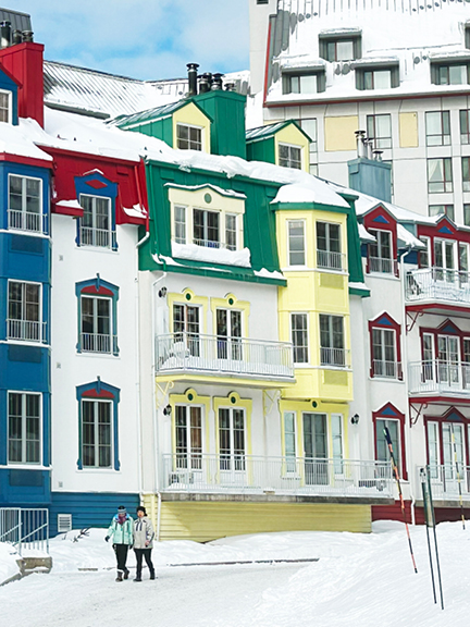 Primary-colored architecture in Mont Tremblant, Quebec, with white siding, yellow accents, a green roof, and bold blue and red contrasts.