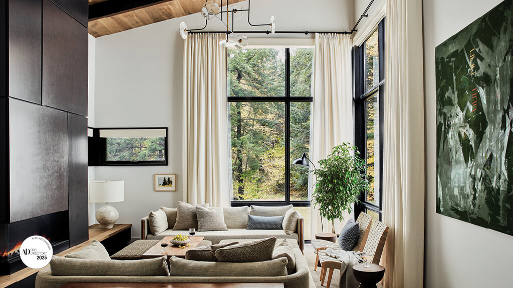 Designed by a Boston interior designer, this Stowe, Vermont living room features modern furniture, tall ceilings, and wood accents.