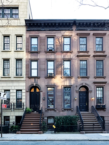 Classic Upper East Side brownstone with black windows and doors, offering NYC interior design inspiration from historic architecture.