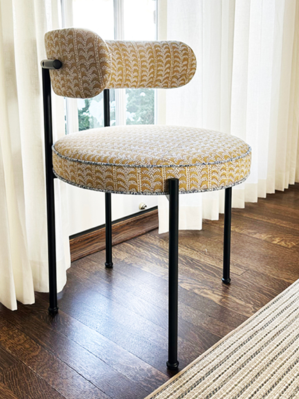 Reupholstered chair featuring yellow Walter G block-print fabric, light blue trim detail, and sleek modern black metal legs.