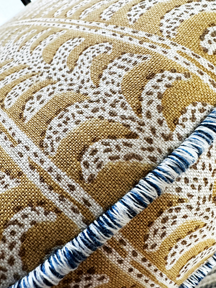 Luxury Upholstery Custom Pillows chair detail featuring Walter G Luxor fabric in Saffron, with Samuel & Sons Blue Jay trim.