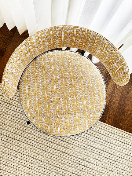 Bird's-eye view of modern round-backed metal chair upholstered in Walter G saffron fabric with blue Samuel & Sons trim.