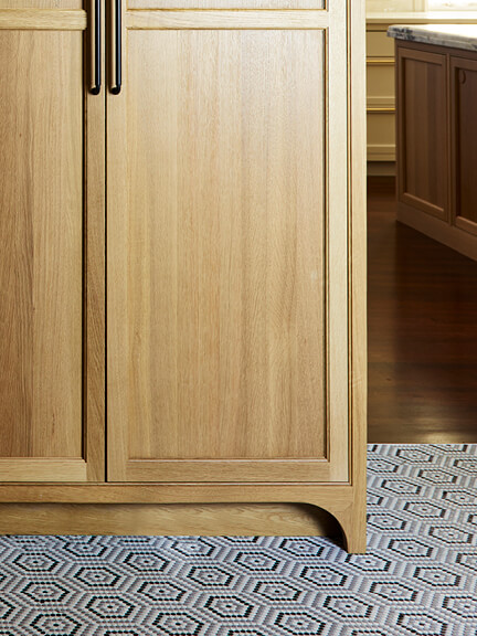 Ann Sacks mosaic tile in white, black, and grey with grey grout, a durable mudroom tile paired with a natural oak pantry.