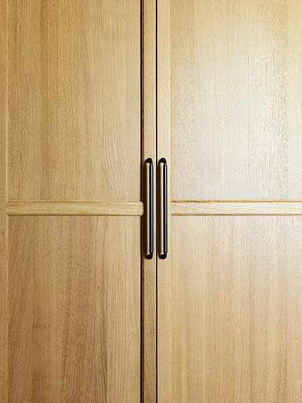 Natural oak cabinet doors with hand-finished bronze pulls from a New England-based hardware company.