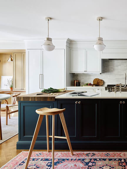 Classic navy blue island in a traditional kitchen of a historic New England brownstone, with a mid-century modern stool and a vintage runner.