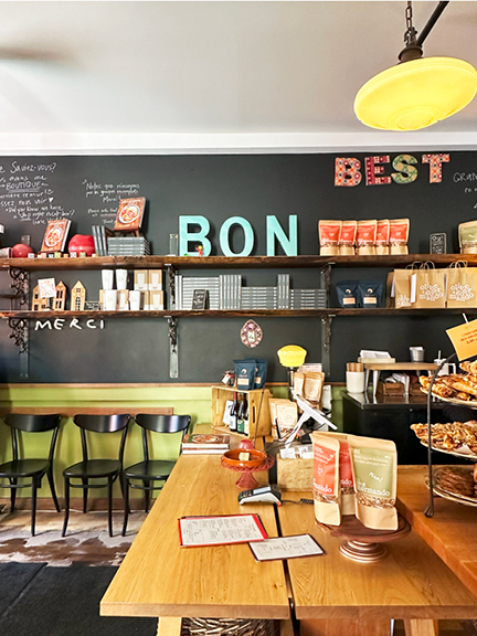 Visit Montreal in the Winter, showcasing Olive et Gourmando with a black wall, lime green accent paint, large scale letters, natural wood tables, and historic lighting.