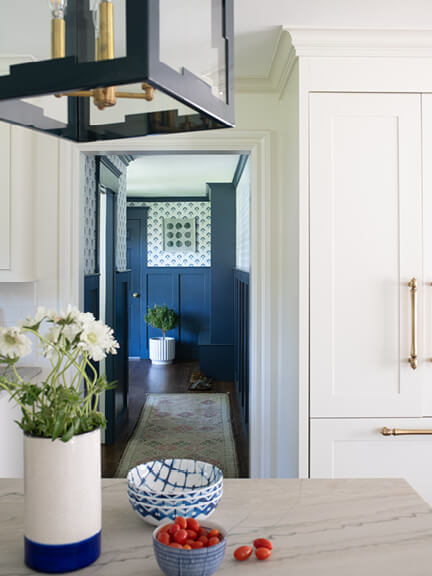 Panel-ready Thermador refrigerator in a Milton custom kitchen with cabinetry by interior designers in Boston and a navy blue lantern light fixture.