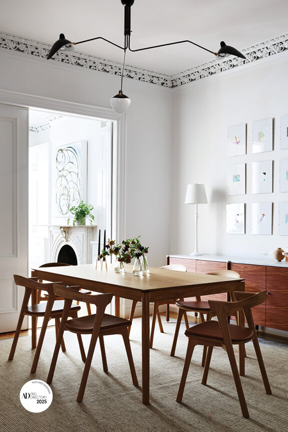 Brownstone interior with preserved details, walnut and marble console, and simple art in a modern setting
