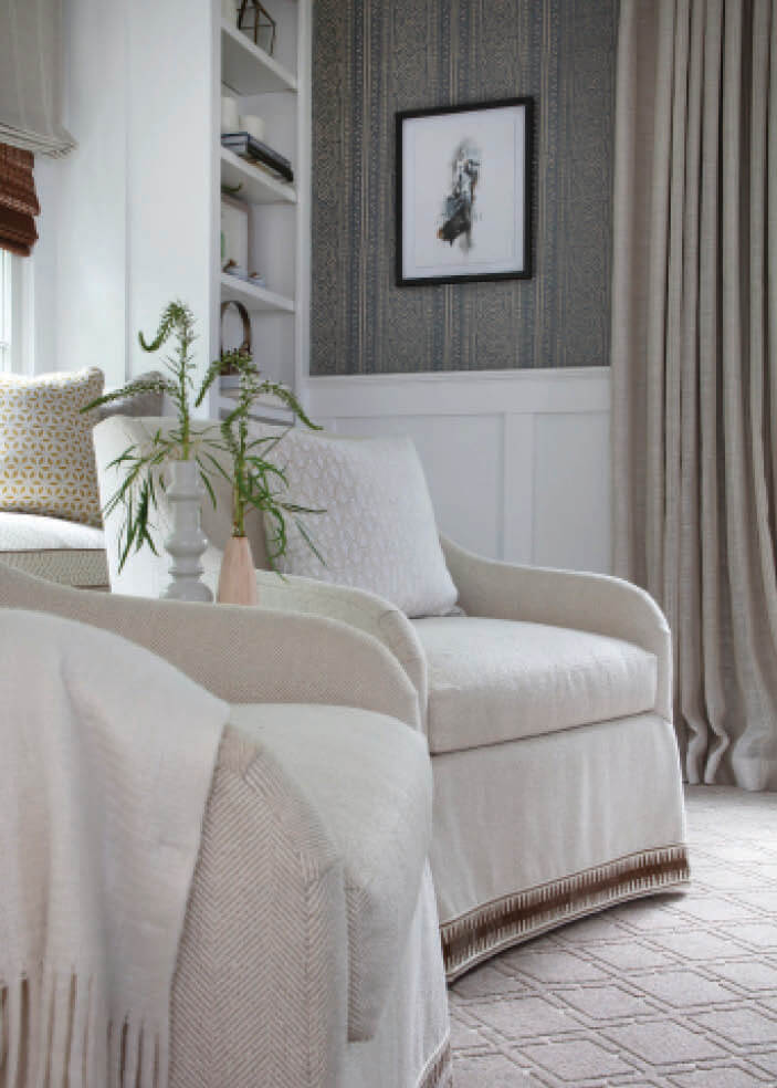 Open floor plan problems addressed with layered design—upholstered chairs, custom carpet, and printed grasscloth wallpaper.