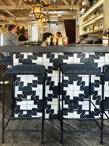Black and white graphic concrete tile floor at a bar in a cool Los Angeles restaurant. Los Angeles Shopping and Dining.