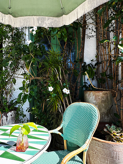 Blue and green tables paired with blue bistro chairs at a stylish restaurant in West Hollywood, featuring playful color and casual outdoor dining.