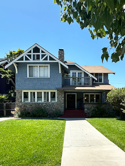 Historic blue-painted home in Van Buren Place, West Adams, Los Angeles, with Craftsman details and period architecture.