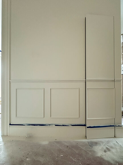 Hidden jib door conceals a coat closet in the entry hall of a brownstone renovation with custom millwork in Boston