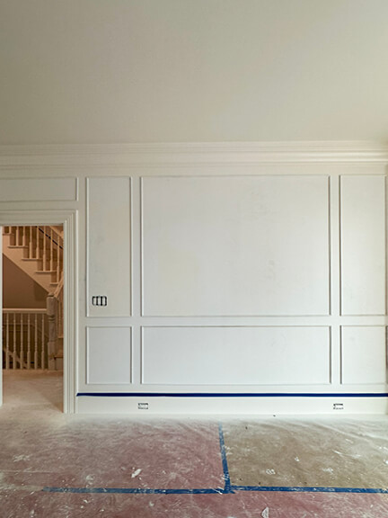 Classic white millwork wraps the stairwell and hallway in this Boston brownstone renovation project