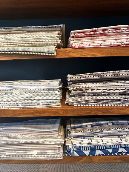 Folded fabrics at Claremont LA showroom, where hand-cut samples and handwritten labels give off nostalgic LA interior design vibes