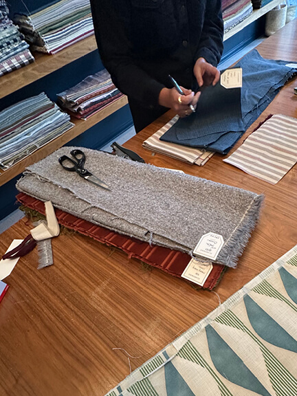 Folded textiles ready to be hand-cut and labeled at Claremont, an LA interior design showroom known for its old-school sampling approach.