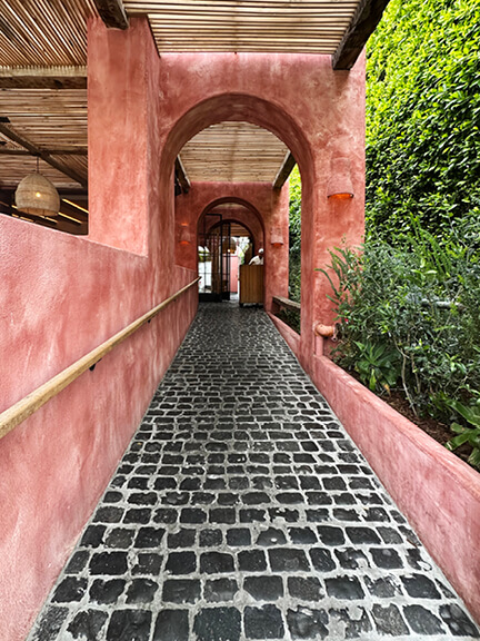 Pink plaster exterior and black tumbled stone at a cool LA restaurant in West Hollywood. Shop and Dine LA.