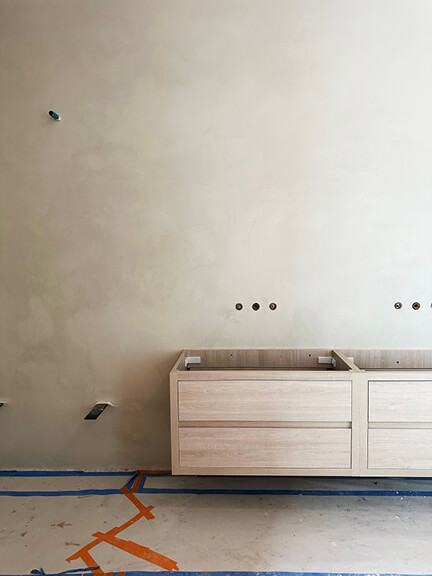 Floating wood vanity with plaster walls and thick marble counters in a Boston brownstone primary bathroom