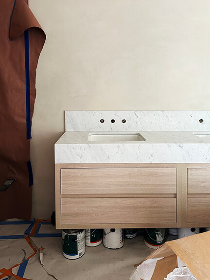 Floating vanity with thick marble backsplash and apron front in a Boston brownstone renovation primary bathroom