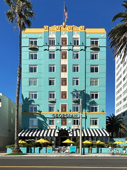 Georgian Hotel in Santa Monica, featuring bold blue and yellow Art Deco design with striped awnings and vintage charm.