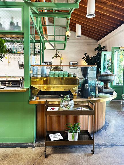 Greenhouse bar interior at The Butcher’s Daughter LA, a custom hospitality space featured in Los Angeles Shopping and Dining.