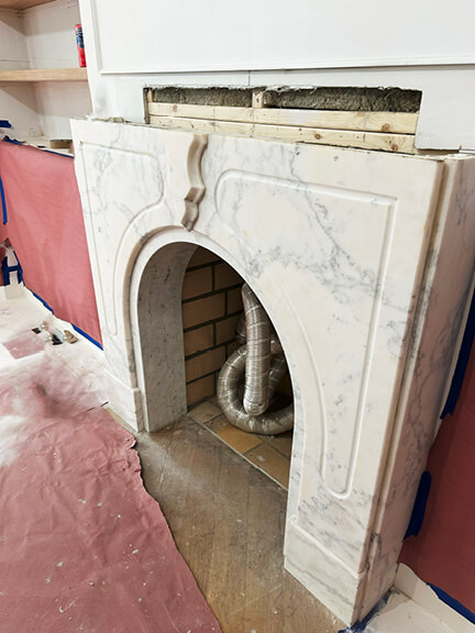 Original stone fireplace with classic detailing featured in a Boston brownstone renovation living room