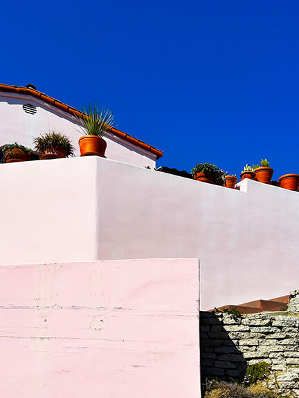 Pink stucco historic home in Los Angeles with arched openings and pastel charm, capturing a lighthearted side of historic home design.