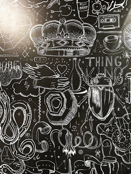 Interior of Alfred’s in West Hollywood featuring bold graffiti art and moody lighting. A standout Los Angeles Shopping and Dining destination.