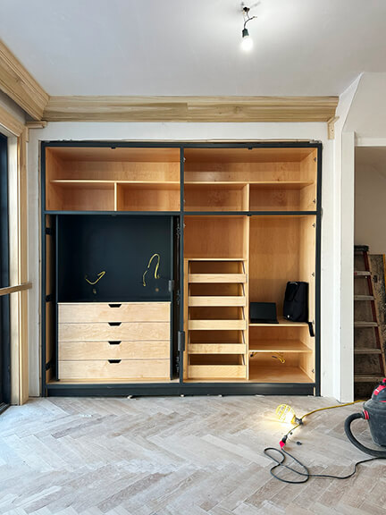 Navy blue kitchen cabinets with white oak herringbone floors in a Boston brownstone renovation by Sarah Scales