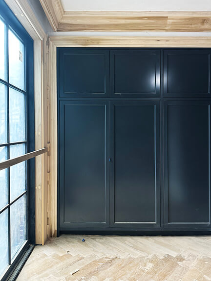 Custom navy blue kitchen cabinets and white oak herringbone floors in a Boston brownstone renovation