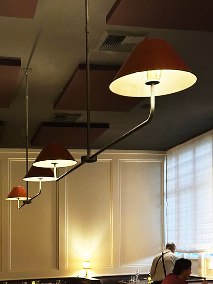 Custom light fixtures at A.O.C. Brentwood, designed by Nickey Kehoe, adding warmth and intimacy to the restaurant’s interior.