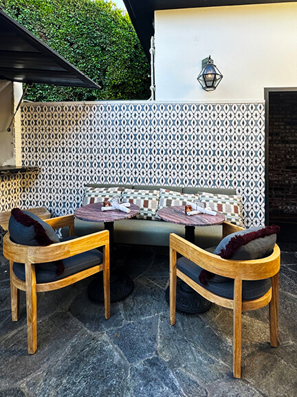 Outdoor dining at Gracias Madre in West Hollywood with lush greenery, relaxed seating, and a warm, inviting vegan restaurant atmosphere.