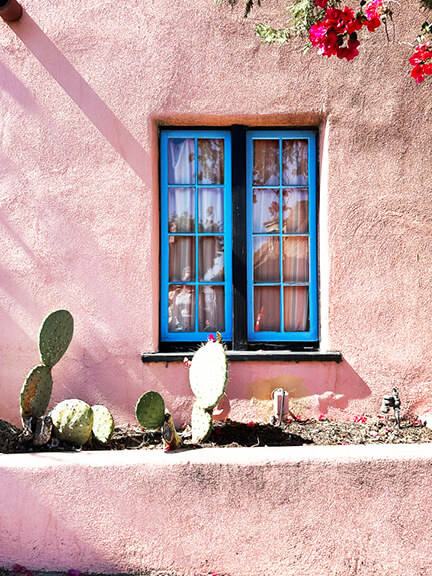 A playful Los Feliz home with pink stucco and bold blue windows—this cheerful take on Mediterranean style feels right at home in LA