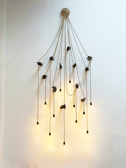 Sculptural wall sconce with organic form and warm glow, seen in a Los Angeles interior design showroom known for bold, art-inspired lighting