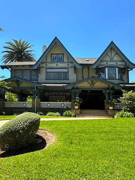 Tudor-influenced Craftsman home in South Pasadena with leaded-glass windows and wraparound porch, rooted in historic home design.