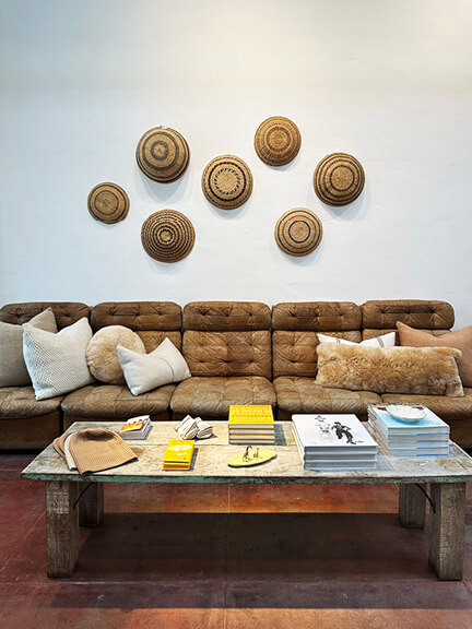 Vintage furniture paired with a wall of woven baskets in a Los Angeles decor store—layered textures that highlight California interior design style