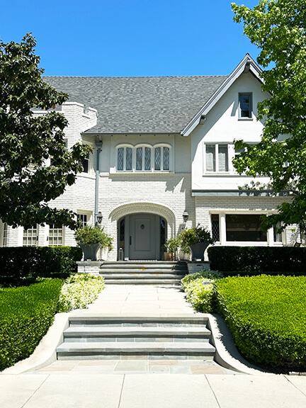 Historic architecture in Los Angeles with white brick facade, classic proportions, and lush, traditional landscaping in Windsor Square.