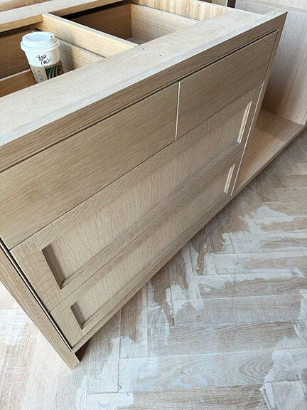 Custom white oak kitchen cabinets and herringbone flooring in a Boston brownstone renovation by Sarah Scales