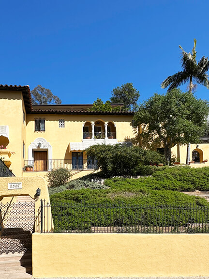 Yellow stucco Mediterranean-style home in Los Angeles with curved façade and tile roof, a relaxed take on historic home design.