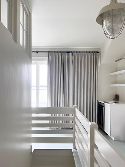 White attic bunk room with blue painted floors and coastal details