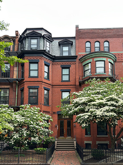 Red-brick Victorian townhouse with octagonal bay window and ornate cornice—classic features of historic home design in Boston.