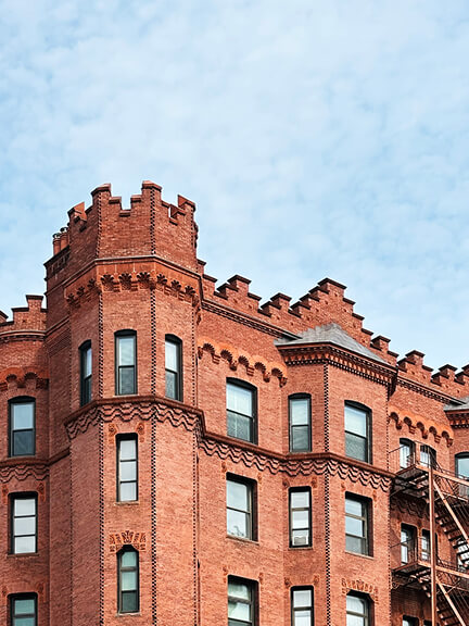 Stepped roofline with a turreted corner and Gothic brick detailing—historic architectural elements on a landmark building in Boston’s Back Bay.