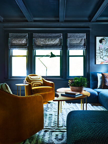 Custom window treatments in a Brookline media room with charcoal linen Roman shades matching the navy sectional in this historic home