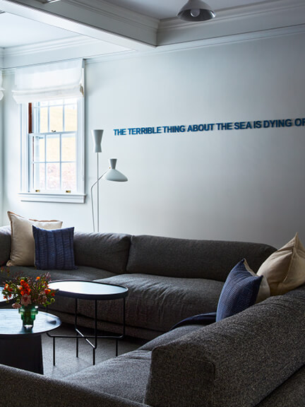 Art in interior design featuring contemporary text-based wall art in a modern family room within a historic Boston home