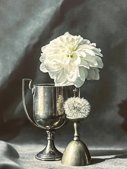 Art in interior design featuring Curtis Speer’s still life of white dahlias in a vintage trophy cup, shown at South Shore Art Center