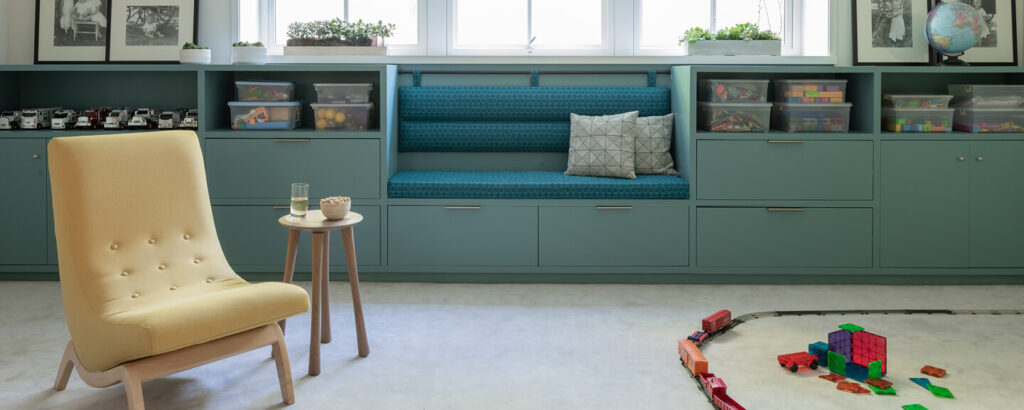 Custom upholstered bench with textured cushion and bolstered seat back in a Hingham playroom designed by South Shore interior decorators