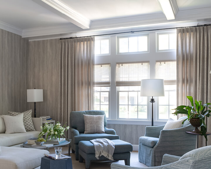 Hingham family room with Lee Jofa drapery, woven wood shades, French wallpaper, and coastal-inspired interior design elements