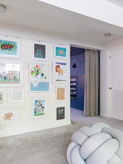 Linen drapery panels offer privacy at the entry to a dark media room, designed by a Hingham interior decorator