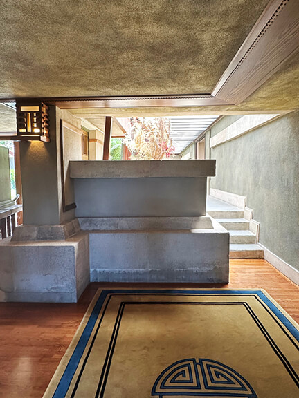 Geometric area rug and concrete interior design at Frank Lloyd Wright’s Hollyhock House, part of postmodern architecture Los Angeles tour